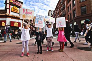 Children protesting and holding up signs