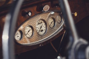Dashboard in a vintage car showing dials and screens