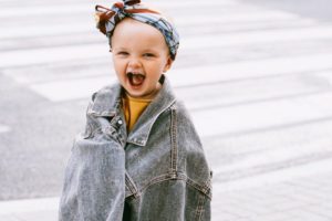 smiling baby in oversize denim jacket